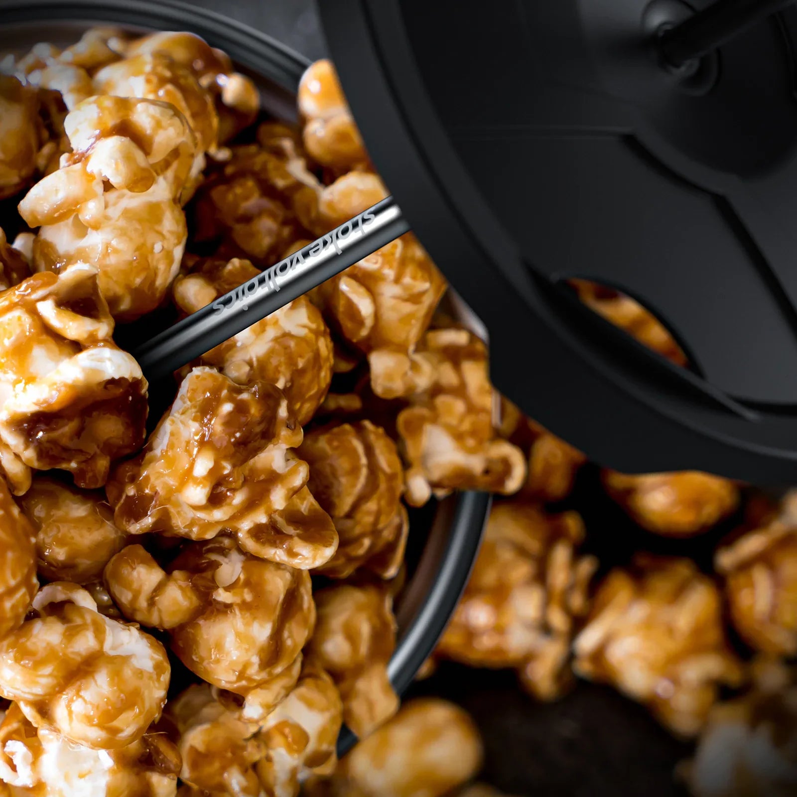Caramel popcorn in Stoke Voltaics kettle pot with black lid, outdoor cookware scene