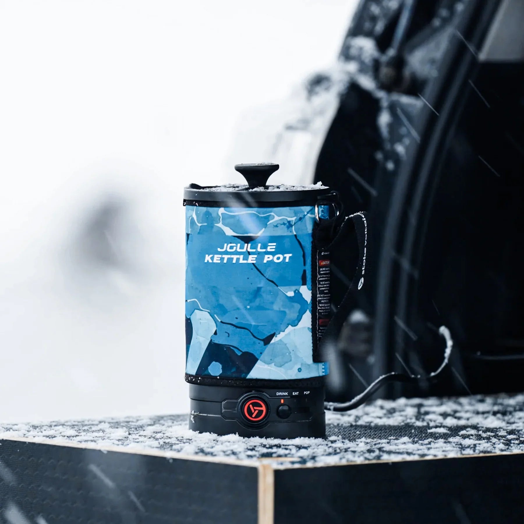 Joulle electric kettle pot with blue glacier design on a snowy table at a winter tailgate
